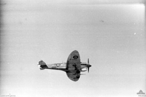 軍用塗装が施された航空機が飛行している白黒写真。
