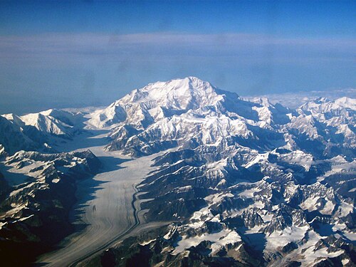 航空写真では、山が多くの小さな山々と氷河に囲まれている。