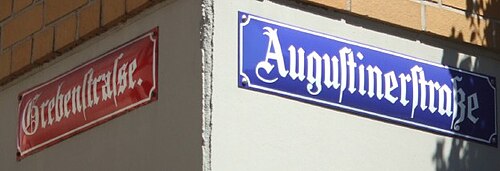 マインツには2種類の異なるブラックレター書体が存在する。赤い看板は「Straße」を「ſs」で表記し、青い看板は標準的なブラックレターの合字「ſʒ」を使用している。