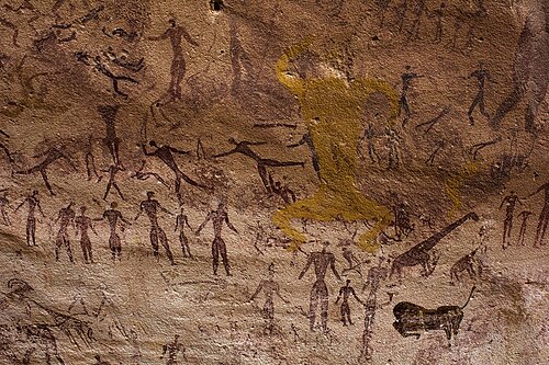 踊る人間の上に黄色の色素の生き物が描かれている