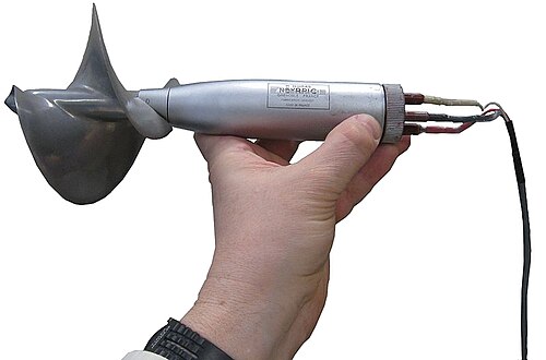 流線型のハウジングに接続された螺旋状のプロペラが手で保持されています。右側にリード線があります。