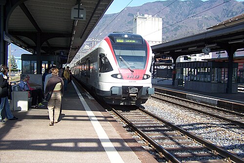 島式ホームの複線を走る赤と白の電車