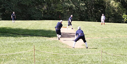 ヴィンテージのユニフォームを着て野球をする男性たち
