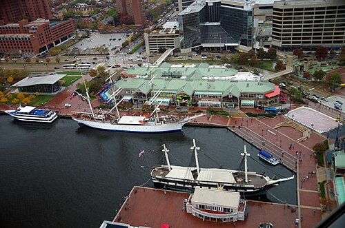 レンガ造りの遊歩道、緑の屋根のショッピングモール、そしてUSSコンステレーション号が見える。ライトストリートパビリオンの前には他に2隻の船が停泊しており、バルコニーの1つには緑色の海の怪物が巻き付いている（リプリーズ・ビリーブ・イット・オア・ノット！）。左側にはババ・ガンプ・シュリンプ・カンパニー・レストランの青い日よけがあり、右側にはマコーミック・ワールド・オブ・フレーバーズの青いMの看板がある。遊歩道の右端にはアイスリンクと円形劇場がある。