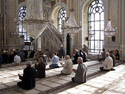 イスタンブールのオルタキョイ・モスクで祈りを捧げるイスラム教徒の男性たち