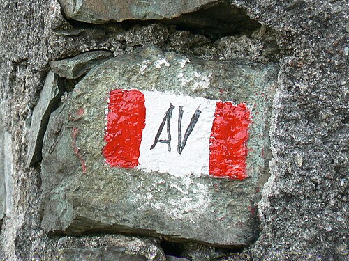 中央に赤と白の旗と「AV」が描かれた岩