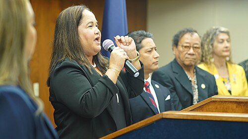 ムニャ・バーンズ議長が同僚らとともに演壇に立っている。