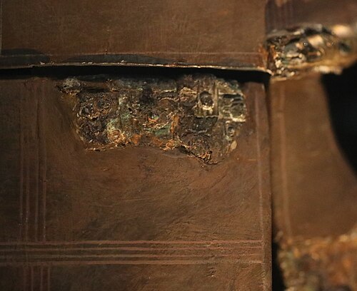 右頬当ての 2 つの破片が結合して蝶番を形成しているクローズアップ カラー写真。左の破片は 1967 年にサットン フーでの再発掘中に発見されました。