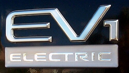 車のバッジ。バッジは銀色で、「EV1」と書かれています。