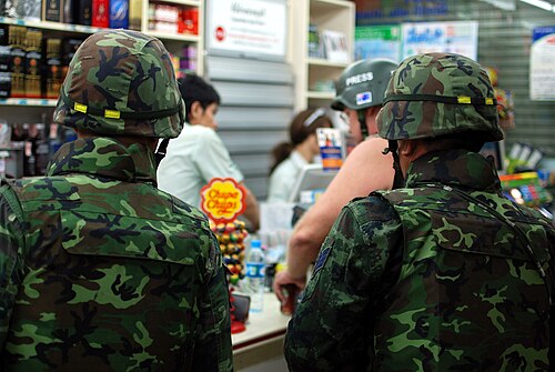 兵士とヘルメットをかぶったジャーナリストが水と食料を買う、シーロム通り