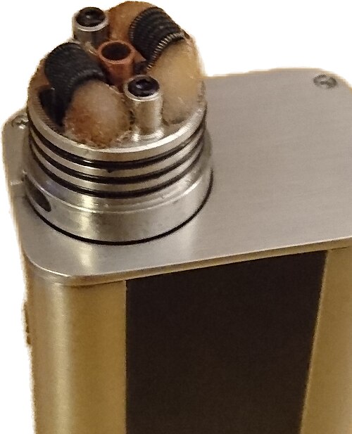 RDA デッキの図。ウィックとコイルが示されています。電子液体は、ウィックが置かれているホッパーとコイル アセンブリの上に滴下されます。