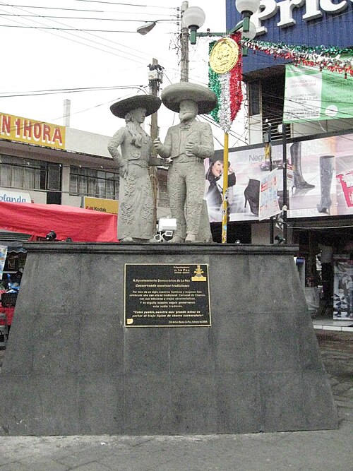 市庁舎前の広場にある、チャロ（メキシコの伝統的なカウボーイ）に捧げられた像。碑文の一部には、「1世紀以上にわたり、私たちの男女は毎年、特徴的な仮面と衣装を身に着けて『チャロのカーニバル』を祝ってきました。この高貴な伝統を守り続けることは、私たちの誇りです」と記されている。