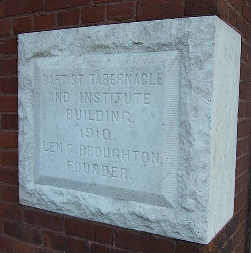 「バプテスト教会の礼拝堂と研究所の建物。1910 年。創設者 LEN G. BROUGHTON」と刻まれた白い石のブロック。