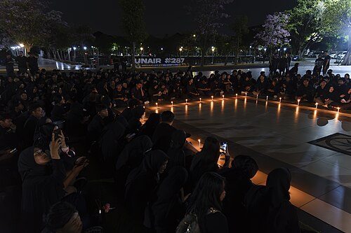 アイルランガ大学で開催されたキャンドルライト集会に、全身黒ずくめの群衆が集まっている様子を写した写真。