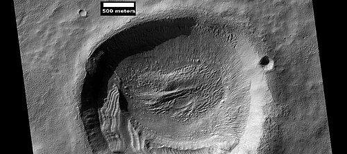 HiWish プログラムの下で HiRISE によって観測されたクレーター内の層状構造。これらの構造は、テキサスで開催された会議で科学者グループによって説明されました。https://www.hou.usra.edu/meetings/lpsc2025/pdf/1938.pdf Blanc. E., et al. 2025. 火星の傾斜した層状堆積物: 気候駆動型中緯度プロセスへの示唆。