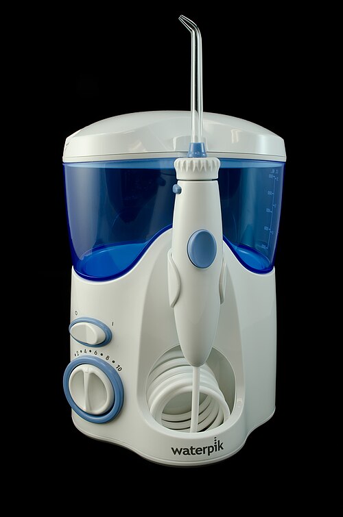 水タンクとノズル付きのハンドルを備えた、卓上型の口腔洗浄器。