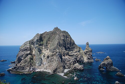 濃い青色の海に囲まれた、険しい岩だらけの島