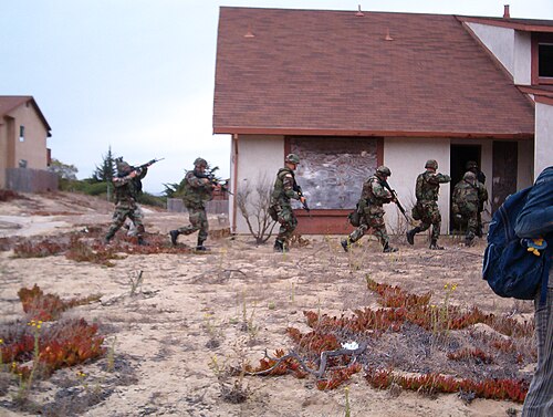 兵士の一団が廃墟となった住宅ビルに侵入する。