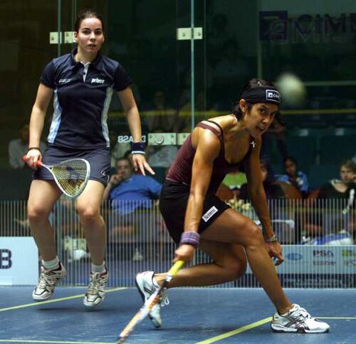 ダークブルーのユニフォームを着たチームメイトがジャンプし、デイビッド選手が彼女にボールをパスします。