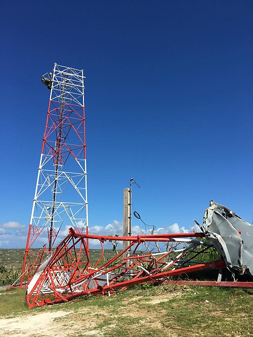 昼間に撮影された通信塔の写真。上半分が損傷して地面に倒れている。