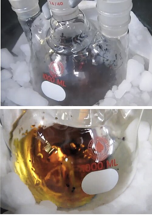 ドライアイスに囲まれた丸底フラスコ内の 2 つの溶液の写真。1 つの溶液は濃い青色で、もう 1 つは金色です。