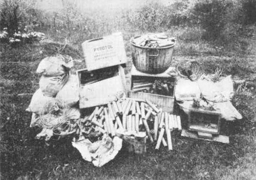 ピロトールの箱、ダイナマイトの棒、爆薬の袋、配線が山積みになっている
