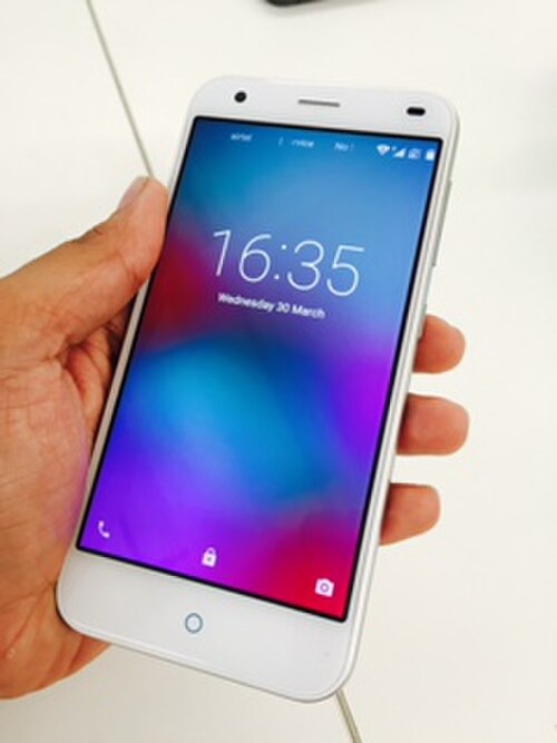 虹色のディスプレイを備えたスマートフォンを手に持っている