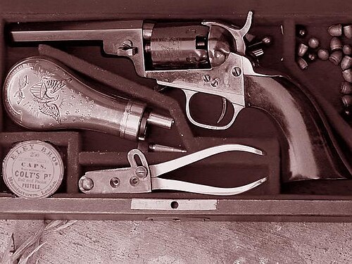 1849年のレバーレスポケットモデル。火薬入れ、弾丸型、弾丸、ボール、雷管などの付属品がケースに入っています。このバリエーションは、以前の「ベビードラグーン」によく似ています。