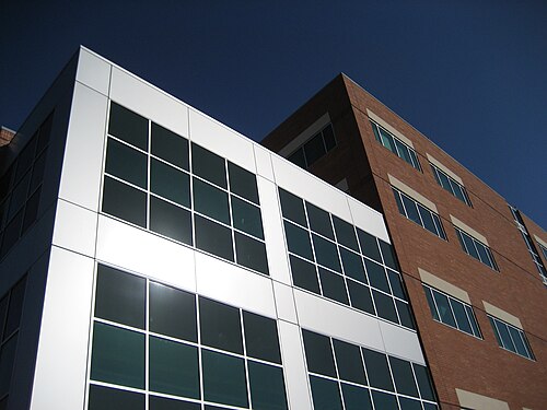 Tuality Healthcare のオフィスビルは、銀色の金属とガラスのアクセントが付いた 5 階建ての赤レンガ造りの建物です。