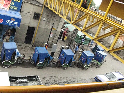 メトロ・ロス・レイエス駅すぐ外のホラシオ・スニガ通りには、客待ちの自転車タクシーが列をなしている。