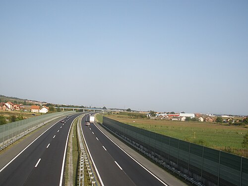 防音壁で区切られた 6 車線の高速道路が田園地帯を走っています。