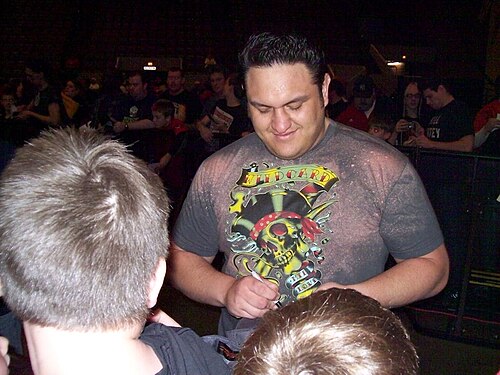 多色のTシャツを着た肌の黒い成人男性がサインをしている