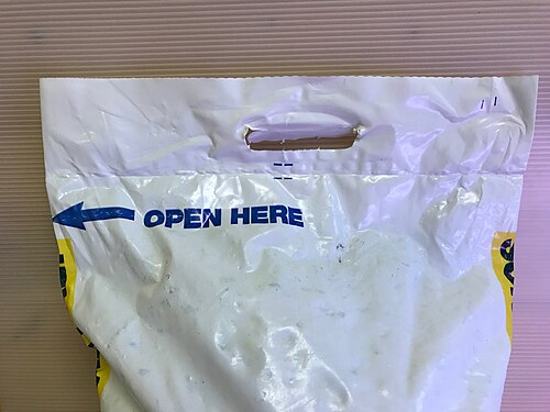 軟水器用塩のビニール袋。厚手のビニールに持ち手が切り抜かれており、持ち運びがしやすいようになっている。