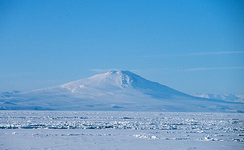 氷に覆われた海越しに見た円錐形の山の遠景