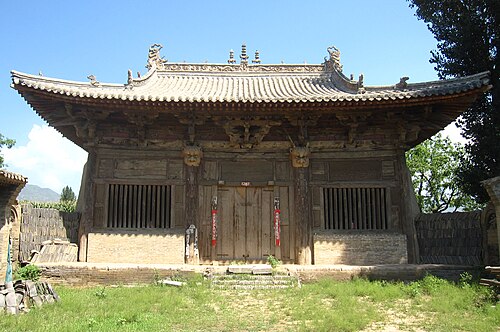 延慶寺の本堂。本堂の後ろには青空が広がっています。芝生の中庭に通じる扉が 1 つあります。