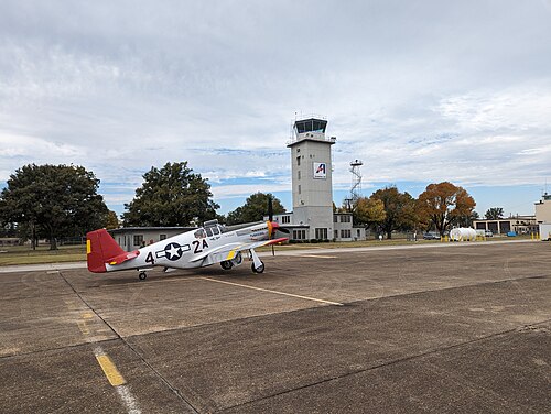 P-51 ムスタング機が正面に停まっている空港管制塔。