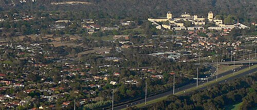 キュー北部の住宅街を南西方向から撮影した空撮写真。スタッドリー・パーク（上）、キュー精神病院（右）、イースタン・フリーウェイのアール・ストリート出口（右下）が写っている。