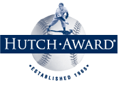 ネイビーブルーの長方形の背景に白で「HUTCH AWARD」の文字が書かれ、野球ボールの前に小さな野球選手が描かれています。野球ボールの下には「ESTABLISHED 1965」と書かれています。
