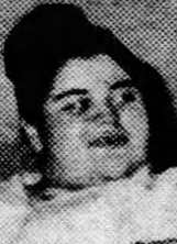 黒髪をトップでお団子にした若い白人女性の新聞写真。