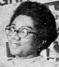 短く自然な髪型と丸い眼鏡をかけたアフリカ系アメリカ人女性。