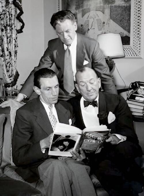 本を見ている3人の中年男性