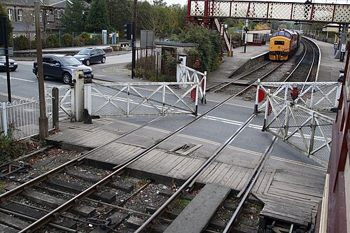 列車通過後、ラムズボトム踏切の遮断機が道路交通のために開かれる。