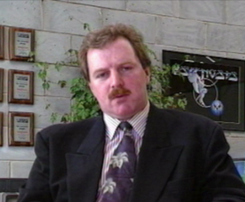 ゲーム開発会社Psygnosisの創設者であるイアン・ヘザリントン氏が机に座っている写真。
