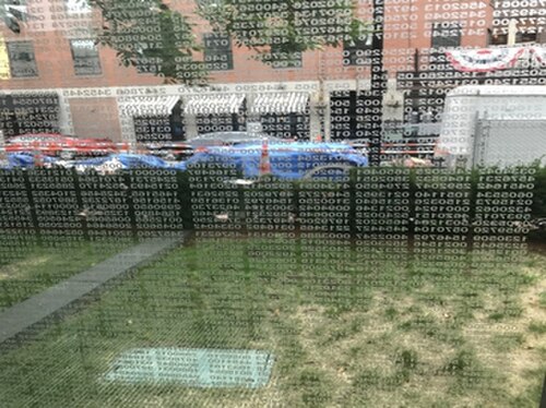 記念碑内部のガラス板の 1 枚の写真。囚人に割り当てられたすべての番号が表示されている。