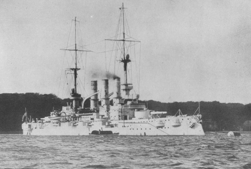 沖合には大型軍艦が停泊しており、その横に小型ボートが係留されている。