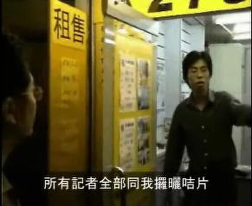 不動産屋の外にいる黒いシャツを着た男