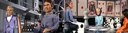 2 つの画像が提示されています。左側では、青い制服を着た 2 人の飛行船乗組員が、1 人が拳銃を持って、ダイナモの形をした金属フレームの前の天井の高い部屋で立っているか座っています。右側では、男性 1 人と女性 2 人が、サイコロ、チェスの駒、トランプをテーマにデザインされた椅子、壁、家具のある部屋で立っているか座っています。2 つのスクリーンショットに写っている人物はすべてマリオネット人形です。