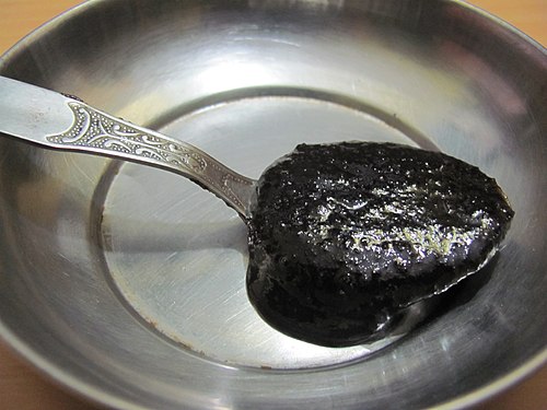 スプーンに盛られた濃い色の液体